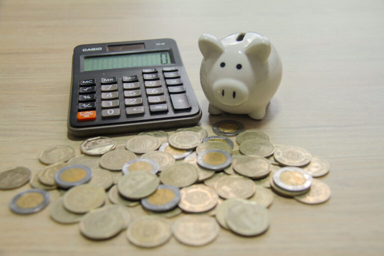 Cómo puedo determinar qué régimen fiscal me corresponde 15 diversas monedas y calculadora sobre una mesa