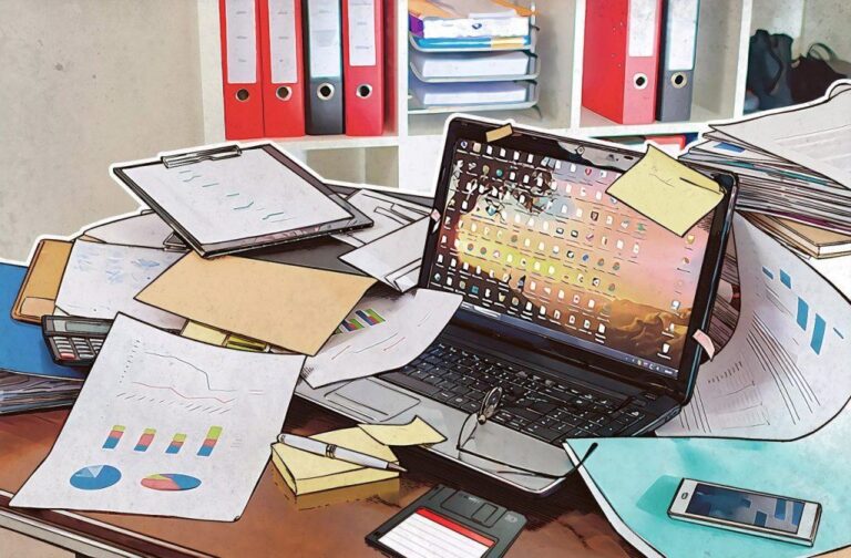 escritorio con computadora y documentos en desorden